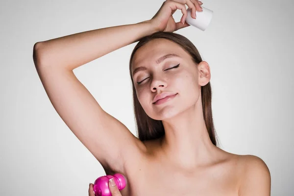 Joven hermosa chica aplica fragante desodorante, ojos cerrados —  Fotos de Stock