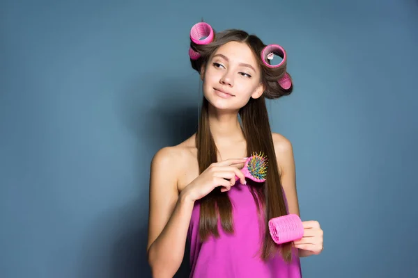 Young beautiful girl going to a party, doing a hairstyle with curlers and combs — Stock Photo, Image