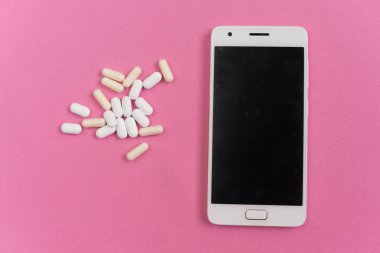 pembe bir arka plan üzerinde beyaz bir smartphone ise bir sürü beyaz tabletler