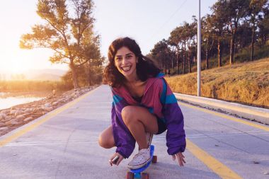 mutlu bir longboard ve gülüyor mor ceket şık kız rides