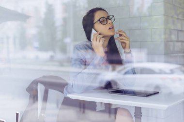 Genç dalgın kız freelancer telefonla pazarlık yapıyor