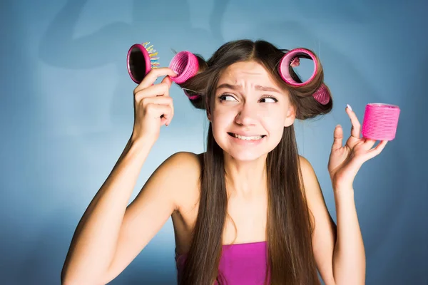 Молодая девушка ранена, делает прическу, на голове розовые волосы бигуди — стоковое фото