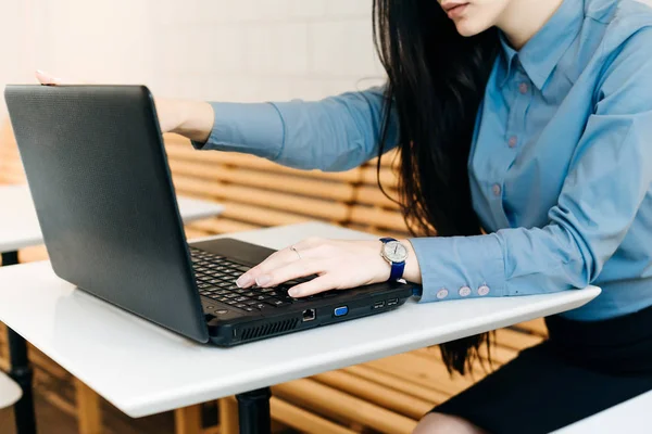 Giovane ragazza freelance in camicia blu che lavora su laptop, stampe — Foto Stock