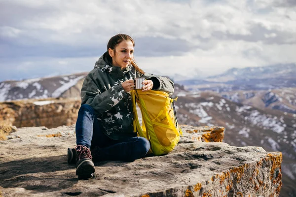 Молода активна дівчина подорожує горами, дивиться на небо і насолоджується повітрям — стокове фото