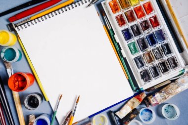 sanatsal fırçaların ve boya, guaj ve kalem mavi bir masada yalan