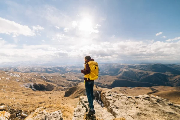 Active girl travels along the Caucasian ridge with a yellow backpack, enjoys nature — Stock Photo, Image