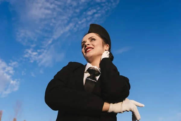 Ευτυχισμένος χαμογελαστό γυναίκα αεροσυνοδός σε ομοιόμορφο αναμονής για την πτήση, φόντο μπλε του ουρανού — Φωτογραφία Αρχείου