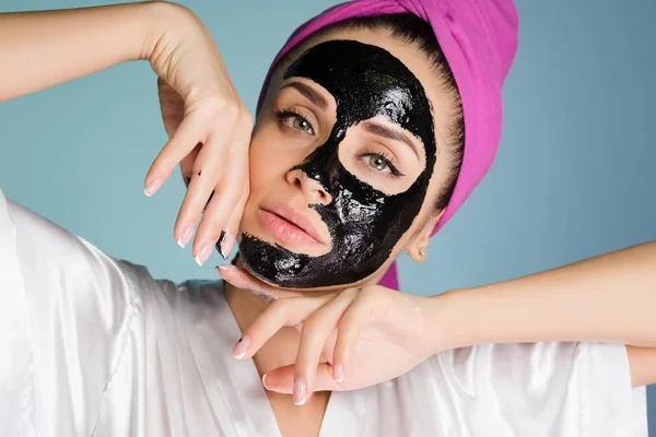 Atrakcyjna, młoda dziewczyna z różowy ręcznik na głowie, chena oczyszczanie maski na twarzy — Zdjęcie stockowe
