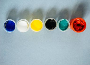 mavi bir masada kavanoz ile renkli bir guaş vardır