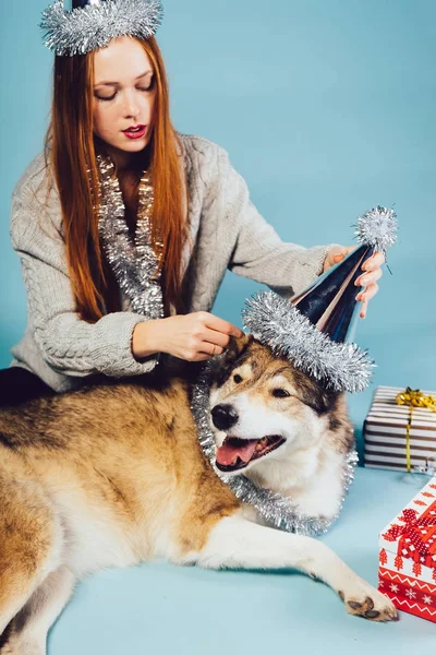 Red-haired 美丽的女孩在喜庆的帽子庆祝新年2018与她的狗 — 图库照片
