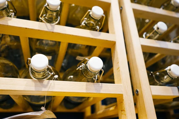 On a wooden rack is a lot of glass bottles — Stock Photo, Image