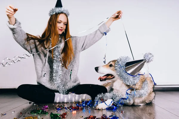 Red-haired 女孩坐在地板上与她的狗, 等待新的一年 2018, 许多银箔和礼物... — 图库照片