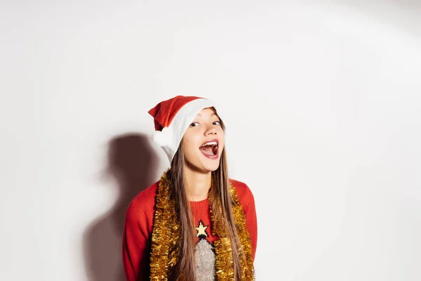 Feliz chica hermosa en una gorra roja como Santa Claus esperando el nuevo año 2018 y la Navidad — Foto de Stock