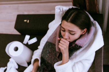 üzgün genç kız çok hasta, öksürük, boynundaki birçok tablet yanında sıcak bir yara