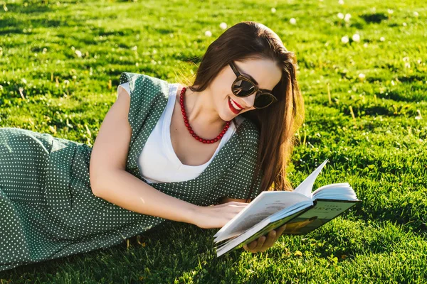 Reading woman on grass.Preparing student in park, sun glasses