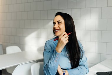 genç esmer kız mavi gömlekli bir kafede güler