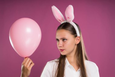 kulakları tavşan başında kızla bir topu elinde tutuyor.