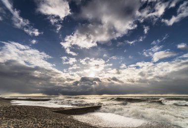 Gün batımında fırtınalı havalarda ıssız taş beach