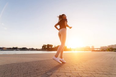 Kız nehirde gün batımında koştu.