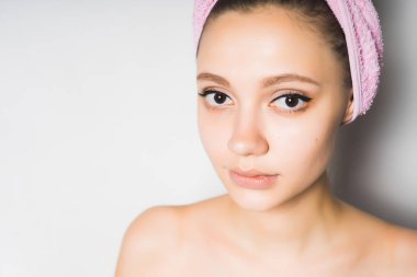 Beyaz bir arka plan karşı kafasındaki bir havlu ile genç kız