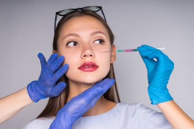 genç bir kız kendini saç köklerinin içine Botox enjeksiyonu yapmak hazırlar