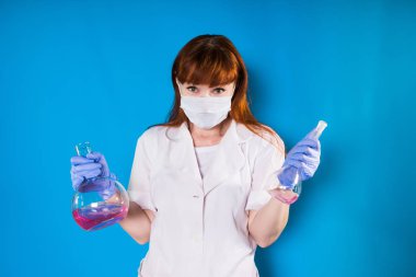 bir kız bir sabahlık ve mavi bir arka plan üzerinde maskeli bir şişesi elinde tutar.