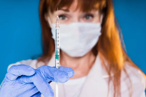Una enfermera con una máscara de guante sostiene una jeringa de insulina — Foto de Stock