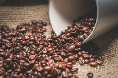 Küçük bir bardak kavrulmuş kahve fasulye bir çanta dökülür