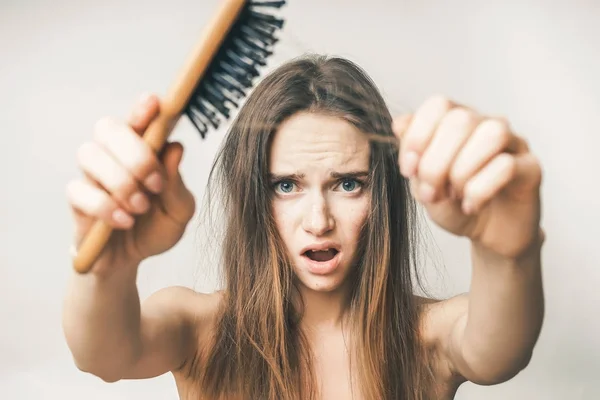Mulher com perda de pente de cabelo, chateado em um fundo branco — Fotografia de Stock
