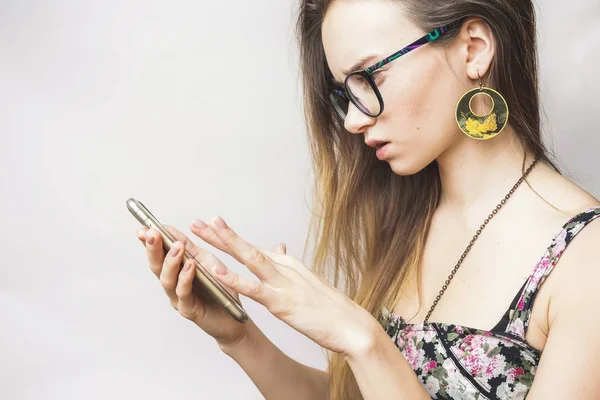 Giovane donna di testo utilizza smartphone su uno sfondo bianco — Foto Stock
