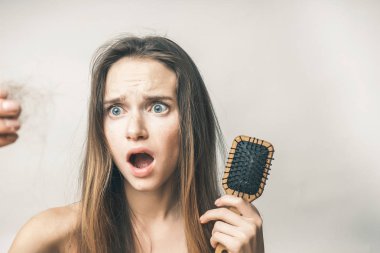 korkmuş bir kız bir tarak onun elinde tutan ve faggots onun elinde görünüyor