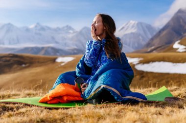 Kafkas Dağları, yawns arka planı mavi uyku tulumu genç kız oturuyor