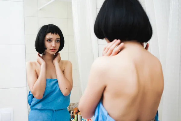 Молода дівчина з коротким волоссям дивиться на себе у дзеркало — стокове фото
