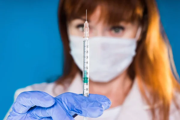Enfermera en una máscara sostiene una jeringa de insulina en las manos — Foto de Stock