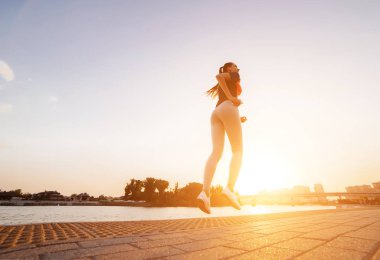 genç bir kız bir akşam nehir boyunca alt görünümü koşmak gerçekleştirir