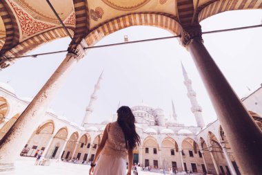 Caminin mavi arka plan üzerinde başörtüsü duran genç kadın gezgin. Yaz tatillerinde seyahat