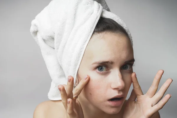 Kvinna trycker ansiktet, letar rynkor på vit bakgrund — Stockfoto