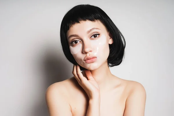 Fiatal lány, Fekete hajú helyezi a maszk, a fehér háttér — Stock Fotó
