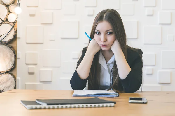 Joven secretaria es molesto sentado a la mesa — Foto de Stock