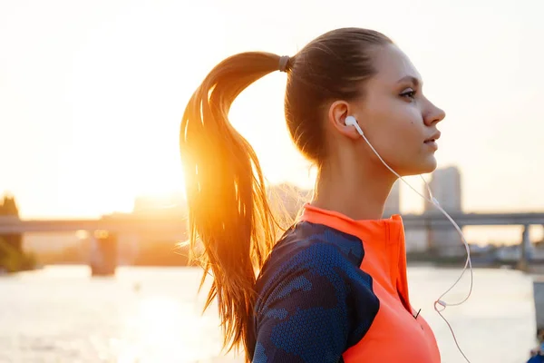 Porträtt av unga kvinnliga löpare jogging nära river front och bron — Stockfoto