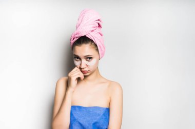 gri bir arka plan karşı kafasındaki bir havlu ile üzgün kız