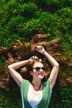 Mutlu yaz gülümseyen kadın rahatlatıcı park, güneş gözlüğü, sağlıklı dişler