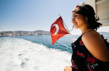 Yatta ayakta, deniz, arka plan bayrak isteyen gülümseyen kadın. Tatil