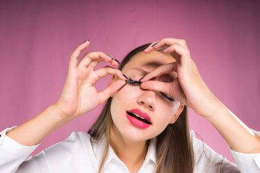 genç kız pembe bir arka plan üzerinde uygulamak yanlış eyelashes