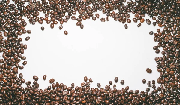Ένα μεγάλο σωρό φρυγμένους κόκκους καφέ που βρίσκεται σε έναν λευκό πίνακα — Φωτογραφία Αρχείου
