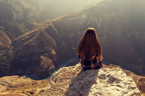 Молода дівчина сидить з нею в горах — стокове фото