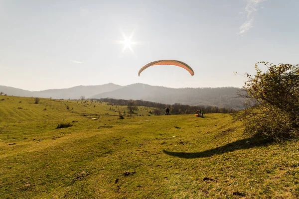 Una joven vuela en un parapente lejos de la ciudad de vacaciones — Foto de Stock