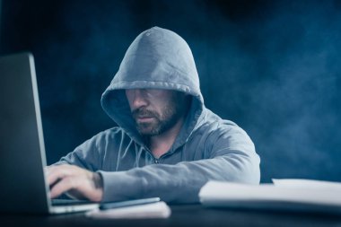 gizemli suç erkek hacker karanlıkta bir dizüstü bilgisayarda yasadışı bir şey yapıyor, sakallı