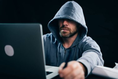 gizemli sakallı adam hacker yüzünü başlık, laptop baskılar altında gizler