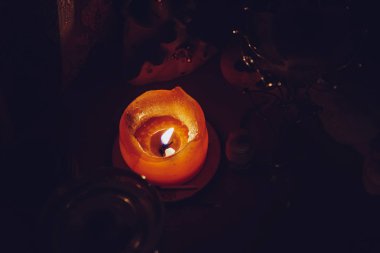 Karanlıkta aromatik bir mum yakar, dinlendirici bir atmosfer oluşturur